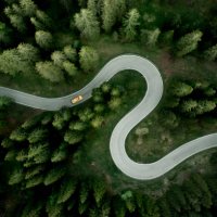aerial view of car traveling on winding mountain road in a forest - travel stock pictures, royalty-free photos & images