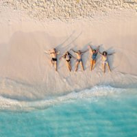 aerial view of friends lying down on the beach - travel stock pictures, royalty-free photos & images