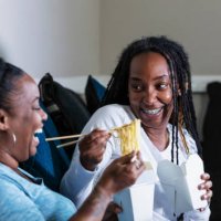 african-american lesbian couple watch tv, eat take out - junk food stock pictures, royalty-free photos & images