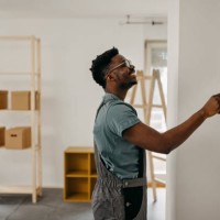 african-american professional painter paints the wall indoors - home decoration stock pictures, royalty-free photos & images