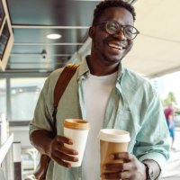 african-american student picking up a coffee - coffee stock pictures, royalty-free photos & images