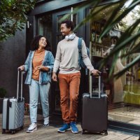 african-american tourists with suitcases in front of the rented apartment - travel stock pictures, royalty-free photos & images