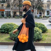african american walking city street carrying oranges in reusable cotton mesh shopping bag - food stock pictures, royalty-free photos & images