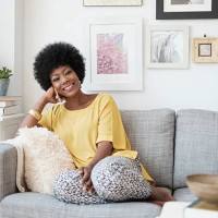african american woman relaxing on sofa - fashion photos et images de collection