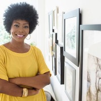 african american woman standing near pictures on wall - home decoration stock pictures, royalty-free photos & images