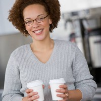 african businesswoman holding take out coffees - junk food stock pictures, royalty-free photos & images