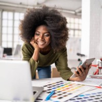 african fashion designer working in studio and using laptop and smart phone - fashion stock pictures, royalty-free photos & images