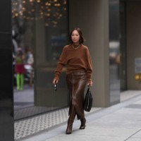 Aimee Song is seen outside Proenza Schouler show wearing golden Tiffany hardware necklace, brown wool pullover, brown leather skirt with matching...