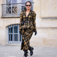 Aimee Song wears black sunglasses, dark yellow black plaid pattern Dior blazer, black leather belt, dark yellow black plaid pattern, black slouchy...
