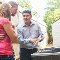 air conditioner repairman explaining cost of repairs to homeowners - home decoration stock pictures, royalty-free photos & images