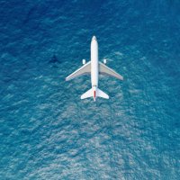 airplane flies over a sea - travel stock pictures, royalty-free photos & images