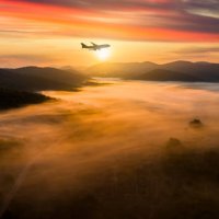 airplane over misty mountains at dawn - travel stock pictures, royalty-free photos & images