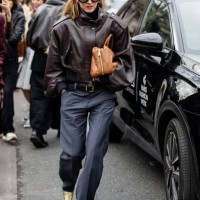 Alexandra Carl wears brown leather jacket, beige bag, grey pants outside Miu Miu during the Womenswear Fall/Winter 2025/2026 as part of Paris Fashion...