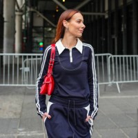 Alice Barbier wears silver earrings, bright cherry red leather bag, navy blue long sleeve striped football jersey Kijun shirt, navy blue striped wide...