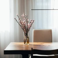 almond blossom twigs in a vase on wooden table in living room. - garden decoration stockfoto's en -beelden