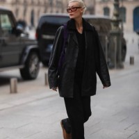 Amalie Gassmann wearing brown shades, a black leather blazer, a black fur shirt, a purple bag, black wide pants and UGG chestnut Classic Mini II Boot...