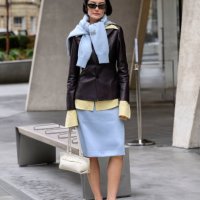 Amalie Gassmann wears Toteme shoes, DeMellier bag, Mithridate skirt, shirt, jacket and jumper and black sunglasses during London Fashion Week...
