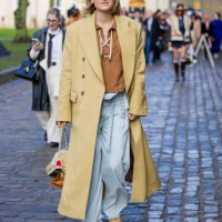 Amalie Nielsen wears beige coat, blue pants, bag, red sunglasses outside Munthe during the Copenhagen Fashion Week Autumn/Winter 2025 on January 30,...