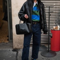 Amelia Gray Hamlin wears blue and green polo neck top, black leather jacket, blue pants, Miu Miu black. Bag, black and blue sneakers, outside...