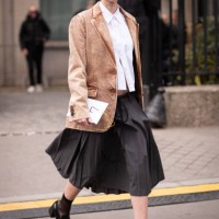 Amelia Gray wears a beige denim Miu Miu blazer, white shirt, black skirt, black loafers and blue Miu Miu bag, outside Miu Miu, during Paris Fashion...
