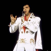 American singer Elvis Presley performing on tour.