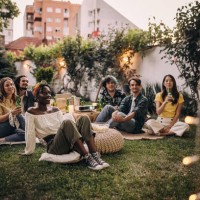 amis regardant un film sur le vidéoprojecteur dans le jardin de l’arrière-cour - garden decoration photos et images de collection