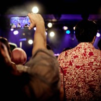among the audience enjoying the concert, taking pictures with a smart phone. - concert stock pictures, royalty-free photos & images