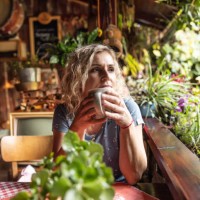 an adult woman enjoys tea on a garden terrace. - garden decoration stock pictures, royalty-free photos & images