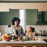 an african-american single mother preparing vegan lunch in the kitchen and smiling with her little daughter - food stock pictures, royalty-free photos & images