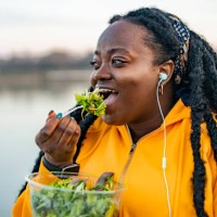 an african american woman eating fresh salad for lunch - food stock pictures, royalty-free photos & images