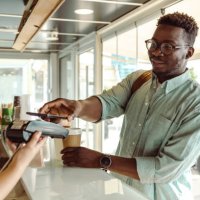 an african american young man paying at the coffee shop - coffee stock pictures, royalty-free photos & images