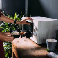 an anonymous caucasian female heating food in the oven - junk food stock pictures, royalty-free photos & images