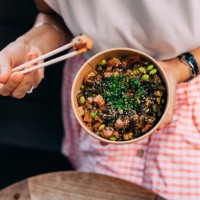 an anonymous woman having outdoor lunch using chopsticks - junk food stock pictures, royalty-free photos & images