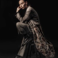an asian chinese male sitting on a stool with fashion clothe looking cool at the camera with black background studio shoot - fashion stock pictures, royalty-free photos & images