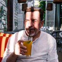 an elderly man drinks lemonade in a street cafe. - garden decoration photos et images de collection
