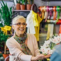 an experienced florist presenting flowers to a customer - garden decoration stock pictures, royalty-free photos & images
