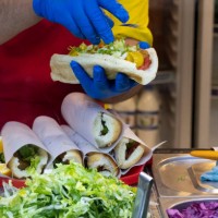 An Iranian-Arab cook prepares a sandwich for a client at a fast-food restaurant in an Arabian food street in the city of Ahvaz 817Km south of Tehran...
