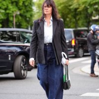 Anastasia Barbieri wears white button up long sleeve shirt, gray wool blazer, high waisted loose navy blue denim jean pants, black bag, brown boots...