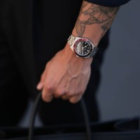 André Hellmundt seen wearing Olymp Hemd black buttoned shirt, matching Suit Supply black long suit pants, Tudor silver watch, MCM black leather logo...