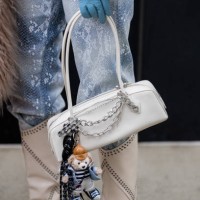 Anna Estrin wears white boots Isabel Marant, knit sweater Celine, jeans For all Mankind, white bag Alaia, blue gloves outside Ulla Johnson during New...