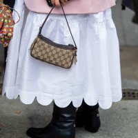 Anna Schürrle wears Gucci bag, white dress, pink blazer, black Chanel boots outside Horror Vacui during the Berlin Fashion Week SS25 on July 03, 2024...