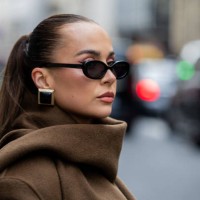 Anna Wein wears brown coat, earrings, sunglasses outside Sacai during Womenswear Spring/Summer 2025 as part of Paris Fashion Week on September 30,...
