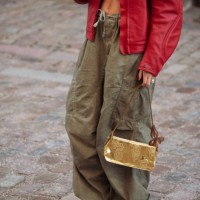 Anna Winck is wearing army green pants, white and grey New Balance sneakers, red leather jacket, golden bag during the Copenhagen Fashion Week AW24...
