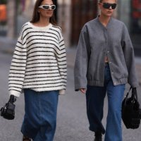 Anna Winter seen wearing white sunglasses, gold and silver necklaces, Edited white and black striped oversized boucle sweater, Edited blue denim long...