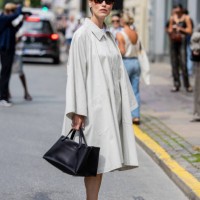 Annabel Rosendahl wears grey oversized button up dress, black bag, heeled sandals, sunglasses outside Gestuz during day four of the Copenhagen...