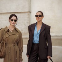 Annabel Rosendahl wears long beige or brown trench coat and brown bag and Darja Barannik wears brown pants, blue shirt and brown blazer and brown bag...