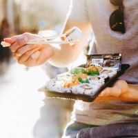 anonymous man eating sushi rolls on street in summer - junk food stock pictures, royalty-free photos & images