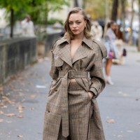 Anouchka Gauthier wears brown belted checkered coat, shorts outside Zimmermann during Womenswear Spring/Summer 2025 as part of Paris Fashion Week on...