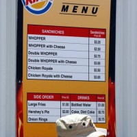 Army soldier waits in line at a Burger King take out restaurant in the army base set up at Baghdad's international airport, 14 July 2003. Soldiers...