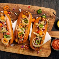 artisan hot dogs in brioche rolls with pickles, onion and relishes. - food stock pictures, royalty-free photos & images